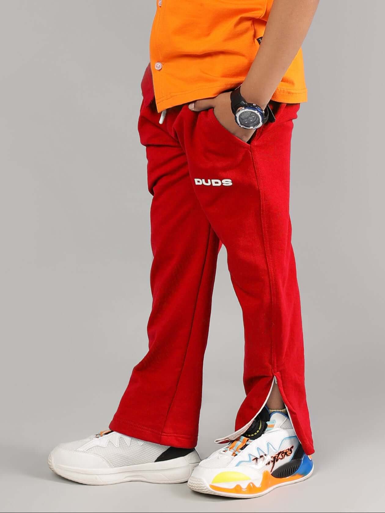 Child wearing HERSHEY JOGGER FOR BOYS & GIRLS RED with orange top and colorful sneakers by DUDS
