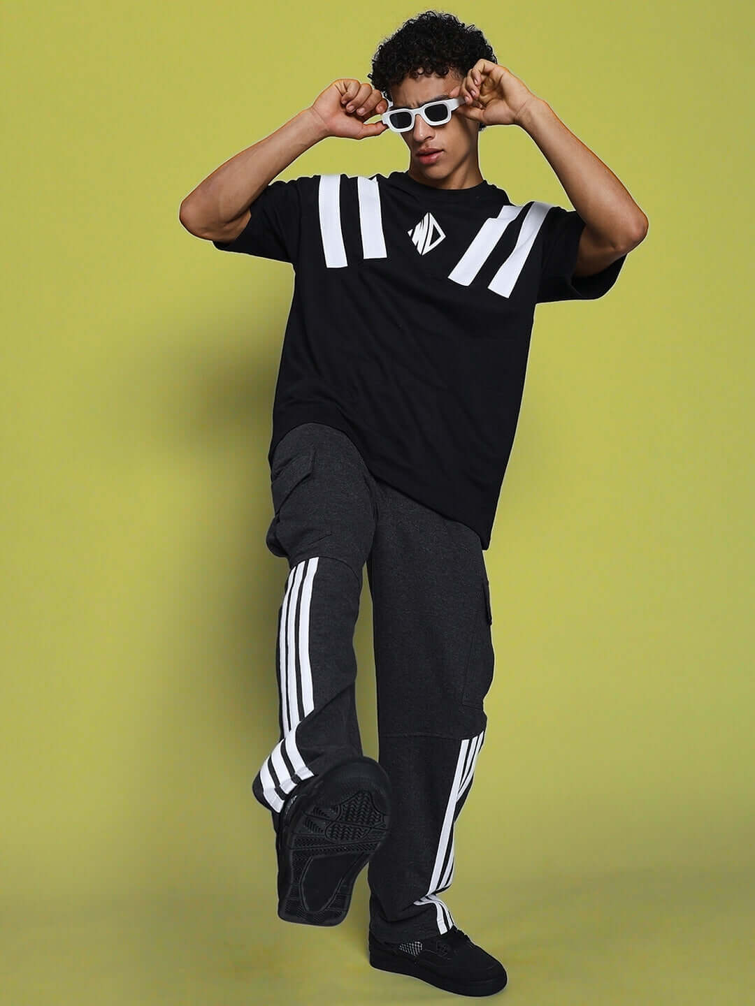 Model wearing REDROIT 5 Pocket Relaxed Fit Joggers in dark grey with white stripes, paired with a stylish black and white shirt.