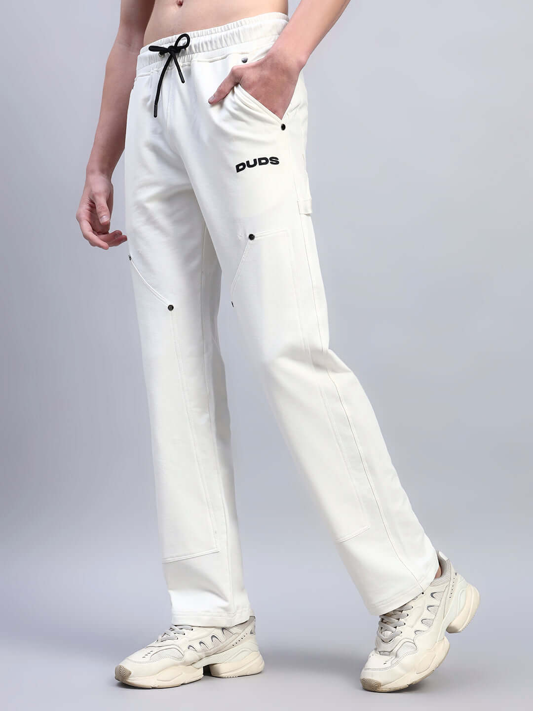 Person wearing white Regulus relaxed-fit joggers by DUDS, featuring customizable fit and comfortable design.
