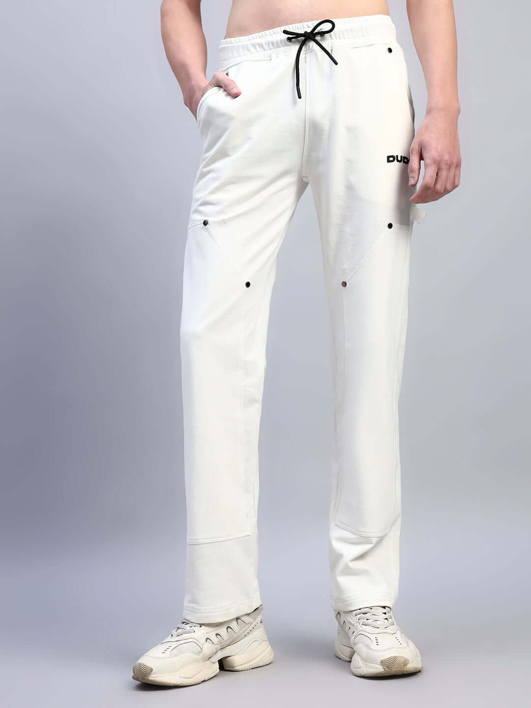Person wearing Regulus Relaxed-Fit Joggers in white with drawstring waist; made by DUDS tailors, customizable size options available.