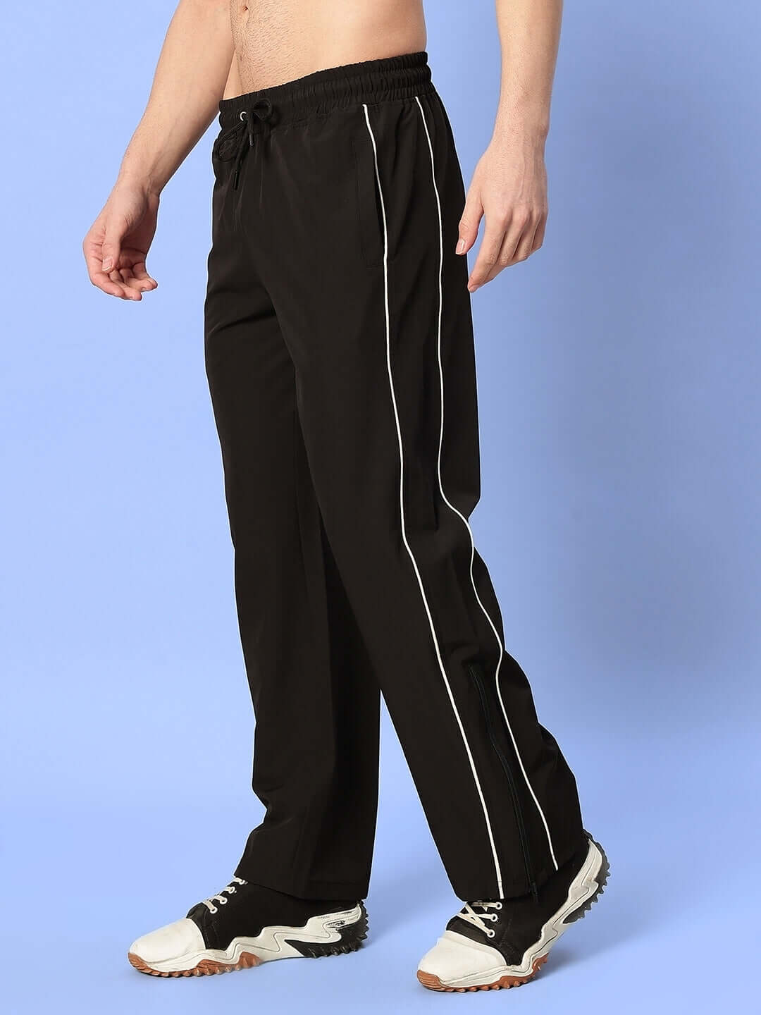 Male model wearing black RELIGHT relaxed-fit joggers with white stripe detail, ideal for casual wear.