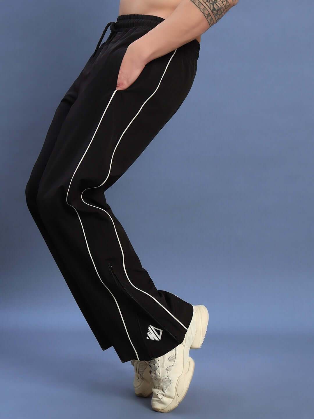 Model wearing RELIGHT Relaxed-Fit Joggers in black with white piping, showcasing comfort and style, available in custom fit for prepaid orders.