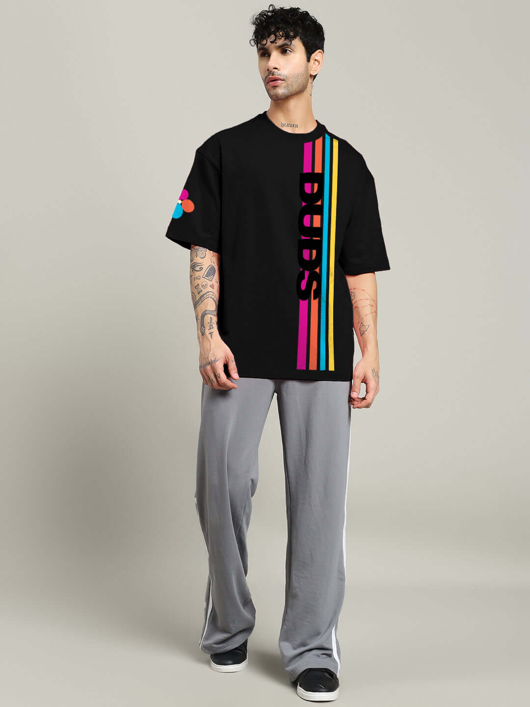 Model wearing RETRO STRIPES OVERSIZED T-SHIRT BLACK with colorful stripes, showcasing trendy fashion for kids. Premium cotton-blend fabric.