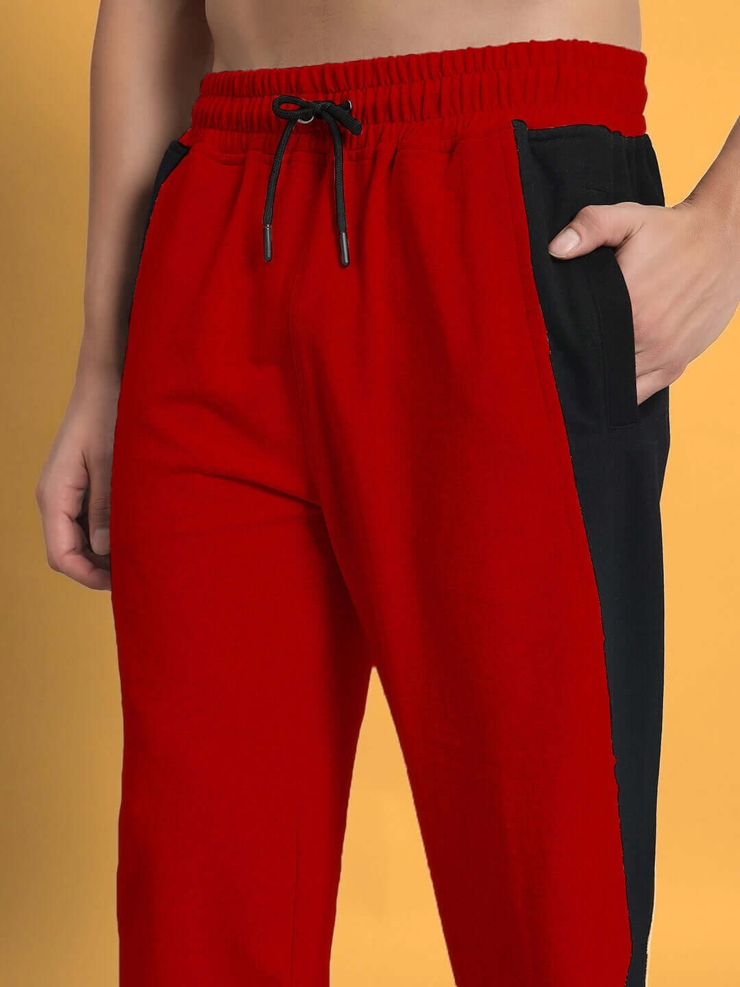 Red-black joggers with side contrast design, elastic waistband, and drawstring, ideal for custom fit orders by DUDS.