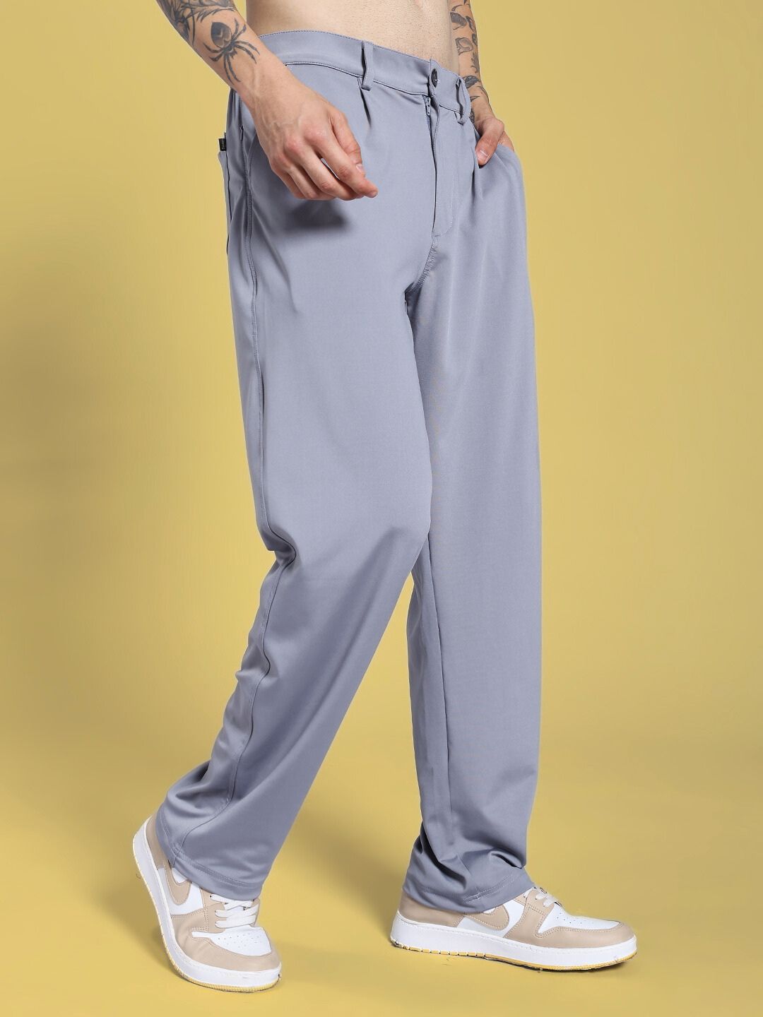 Person wearing REVOXX RELAXED FIT JOGGER GREY showcasing movement and flexibility on yellow background.