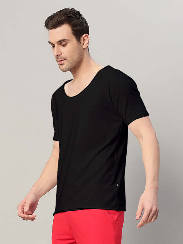 Man wearing Ricky Regular Fit Black T-Shirt made of 100% cotton, styled with bright red pants, showcasing casual fashion.
