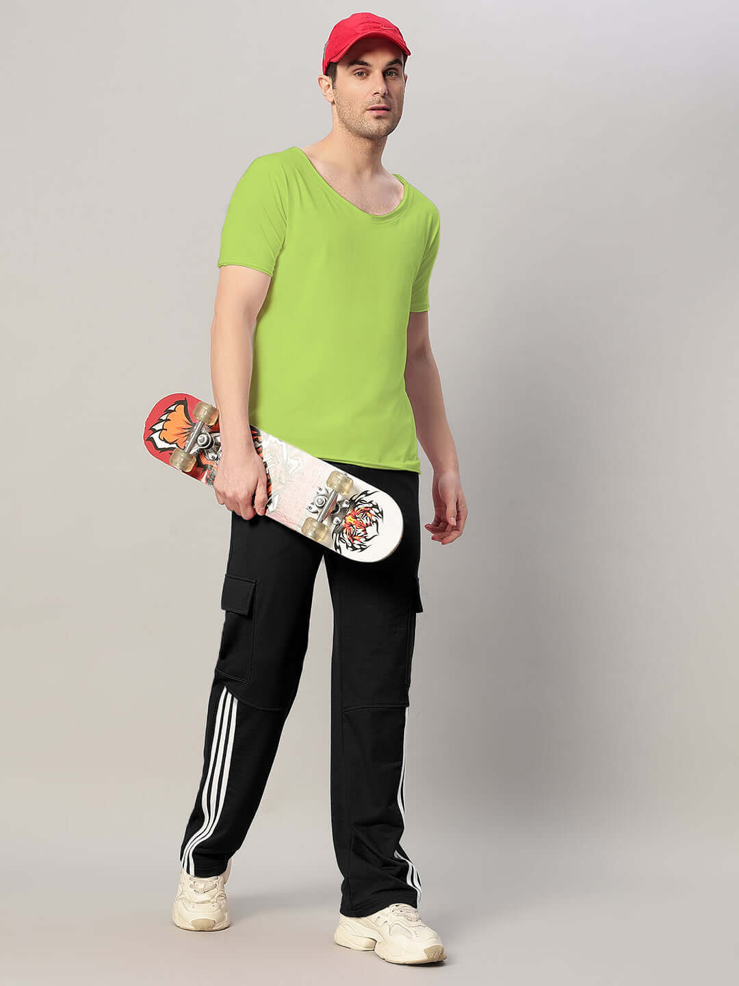 Man wearing Ricky Regular Fit Neon Green T-Shirt, holding skateboard, dressed in casual attire.