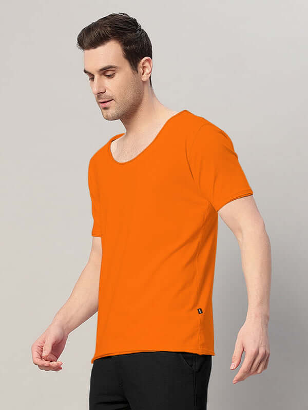 Man wearing RICKY REGULAR FIT T-SHIRT ORANGE, showcasing vibrant color and classic fit against neutral background.