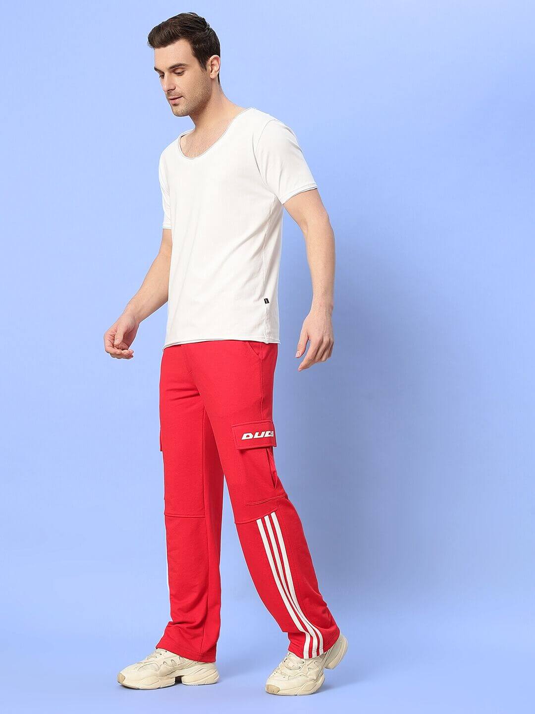 Person wearing Ricky relaxed fit co-ord set in white and red with elasticated waistband joggers featuring contrast panel, unisex style.