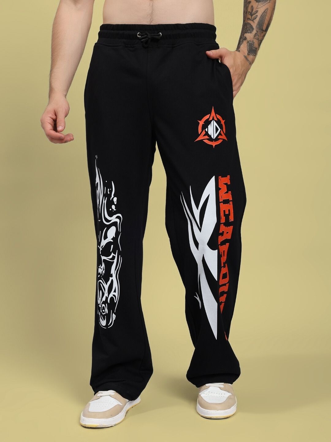 Man wearing RIFT RELAXED FIT JOGGER IN BLACK with graphic design on legs, showcasing comfortable and stylish casual wear.
