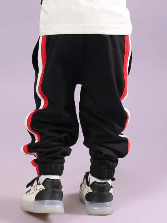 Child wearing RIGHTMAN JOGGER FOR BOYS & GIRLS BLACK with red and white stripes, ideal for active kids.