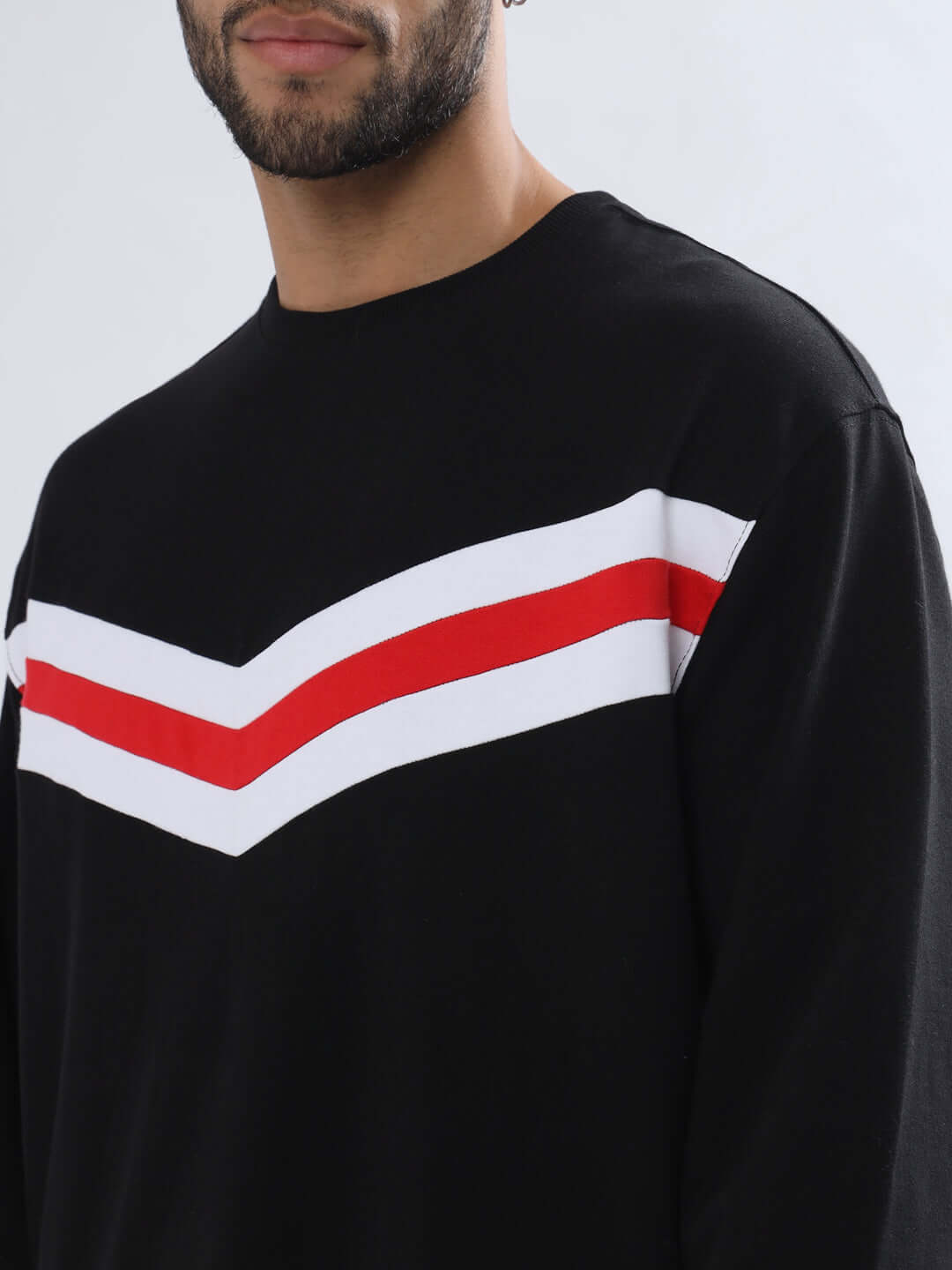 Male model wearing RIGHTMAN OVERSIZED SWEATSHIRT in black with red and white chevron stripes, made of premium cotton fabric.