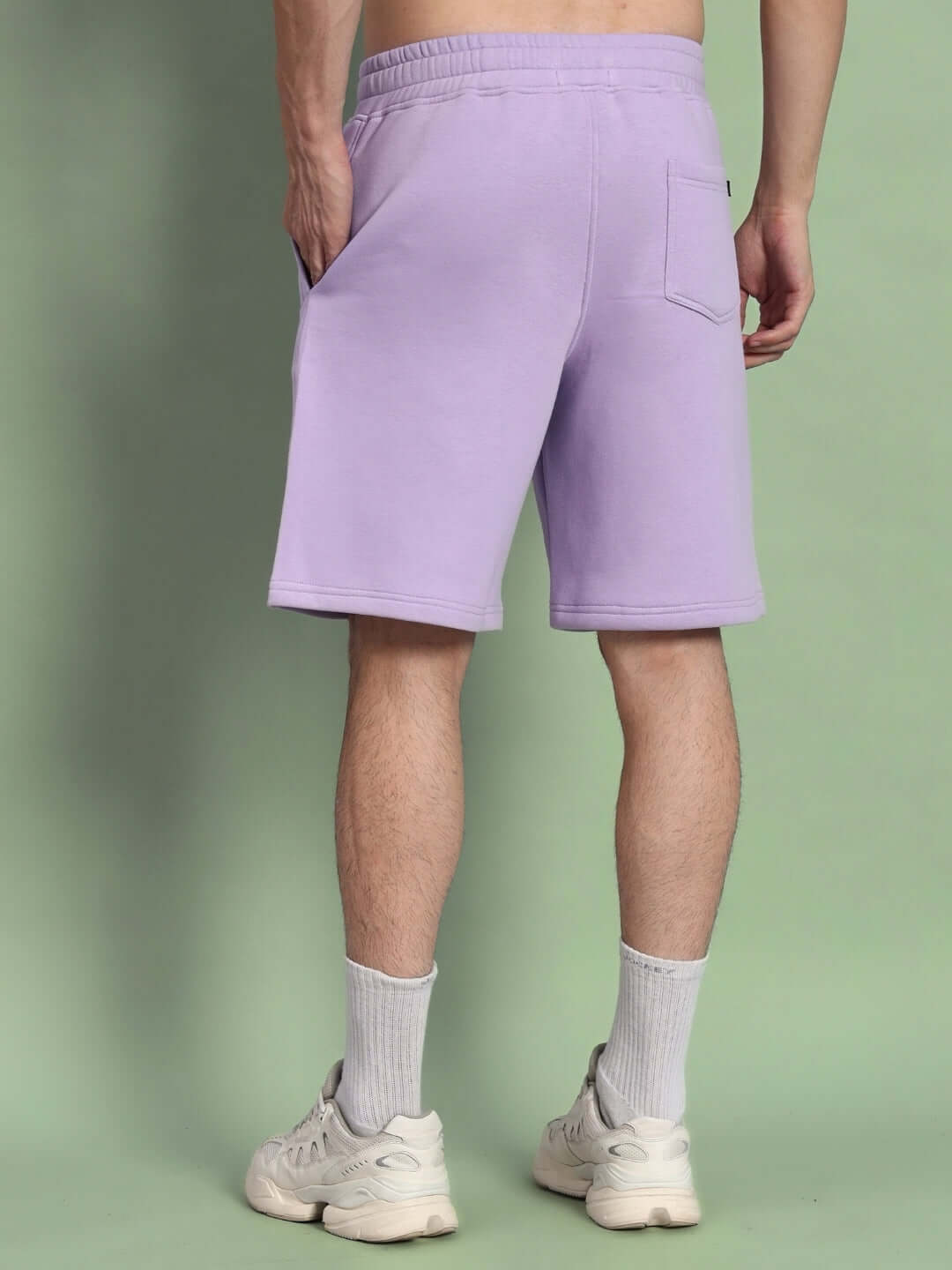 Back view of WEARDUDS RITZY FLEECE SHORTS LILAC, featuring a relaxed fit and pocket detail, shown on a male model.