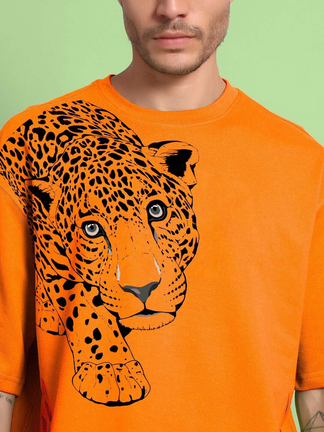 Person wearing ROBERTO LEOPARD PRINTED T-SHIRT ORANGE with leopard graphic