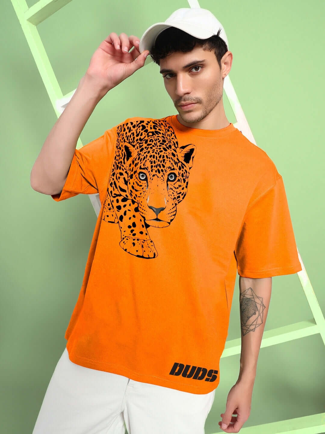 Man wearing a ROBERTO LEOPARD PRINTED T-SHIRT ORANGE featuring a leopard graphic on vibrant orange background.