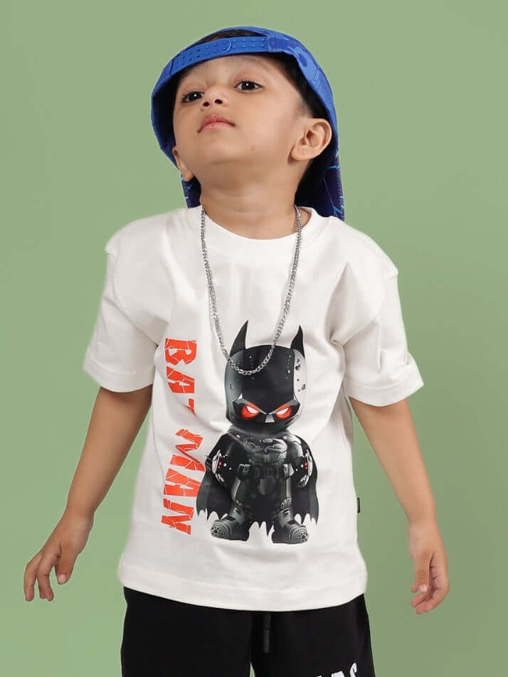 Child wearing ROBIN T-SHIRT FOR BOYS GIRLS OFF WHITE with a graphic design, styled with a blue cap and necklace.