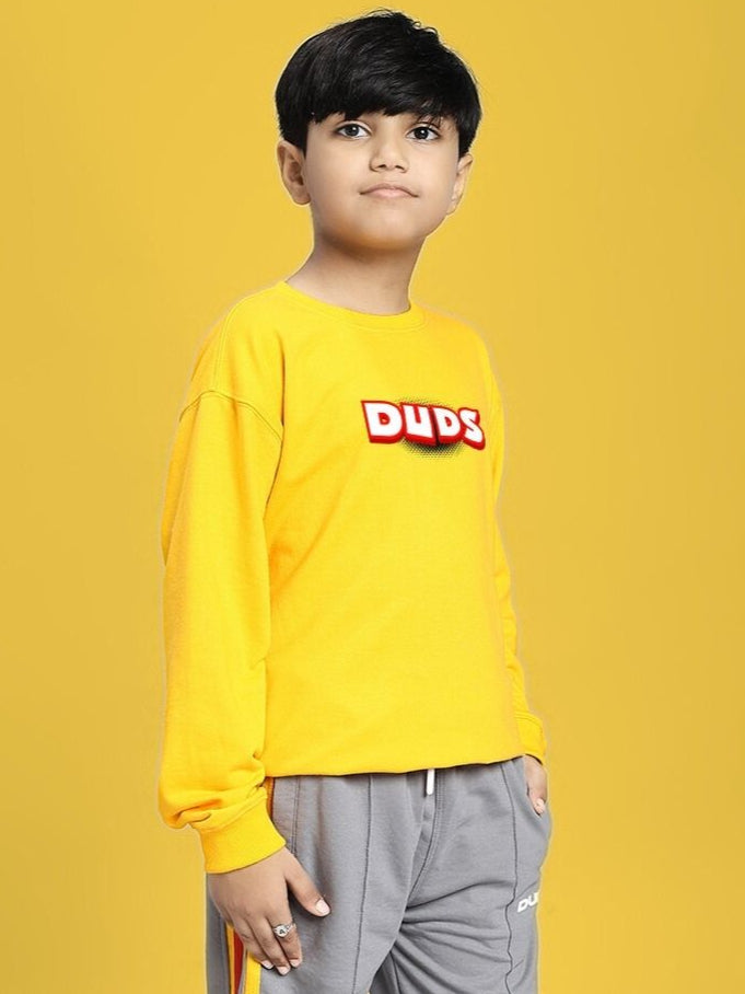 Child wearing ROBLOX SWEATSHIRT FOR BOYS AND GIRLS YELLOW with fun design, standing confidently against a vibrant yellow background.