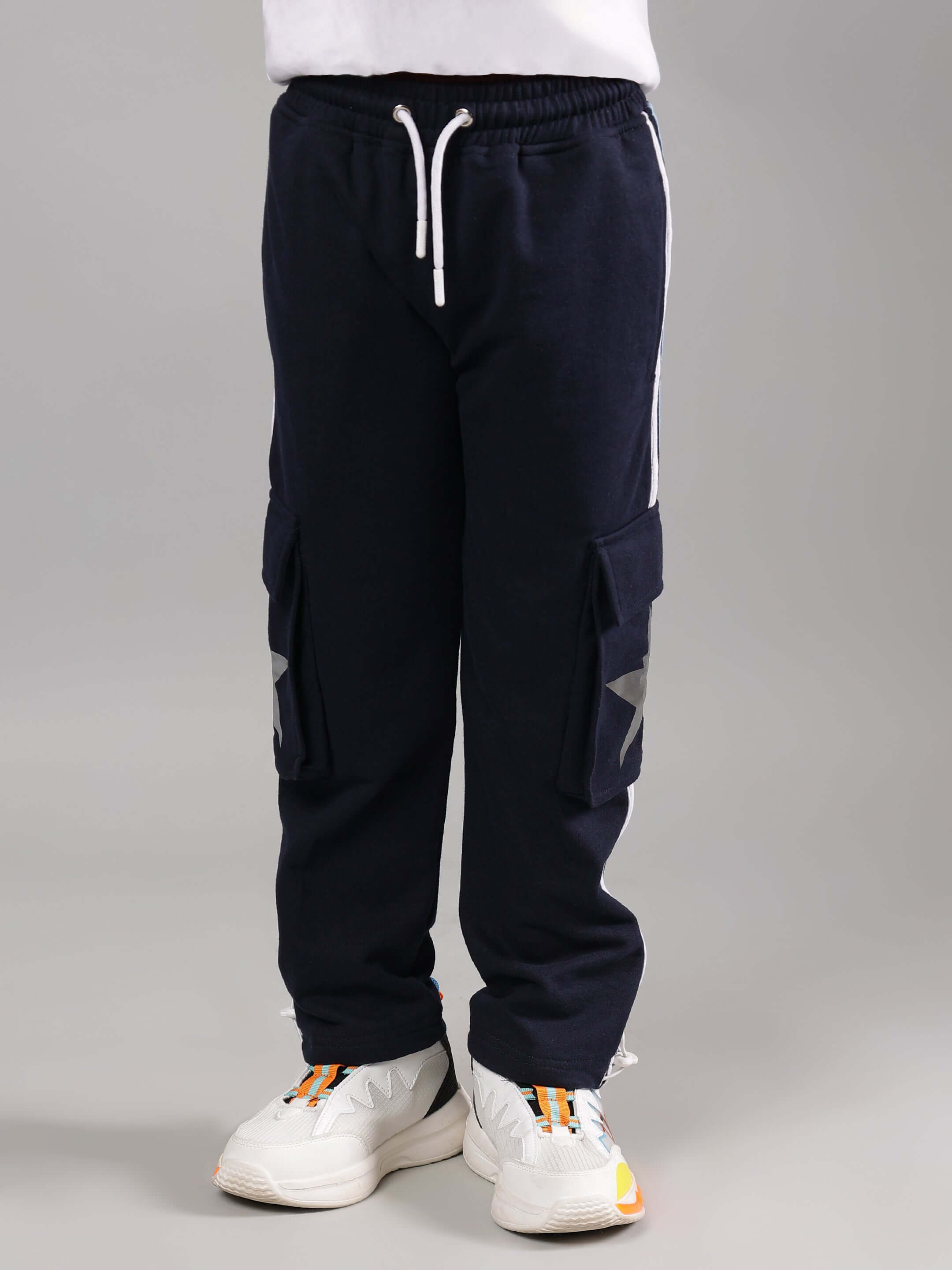 Child wearing ROBO MINIONS CO-ORD FOR BOYS GIRLS WHITE NAVY pants with white sneakers, showcasing the comfortable and stylish design.