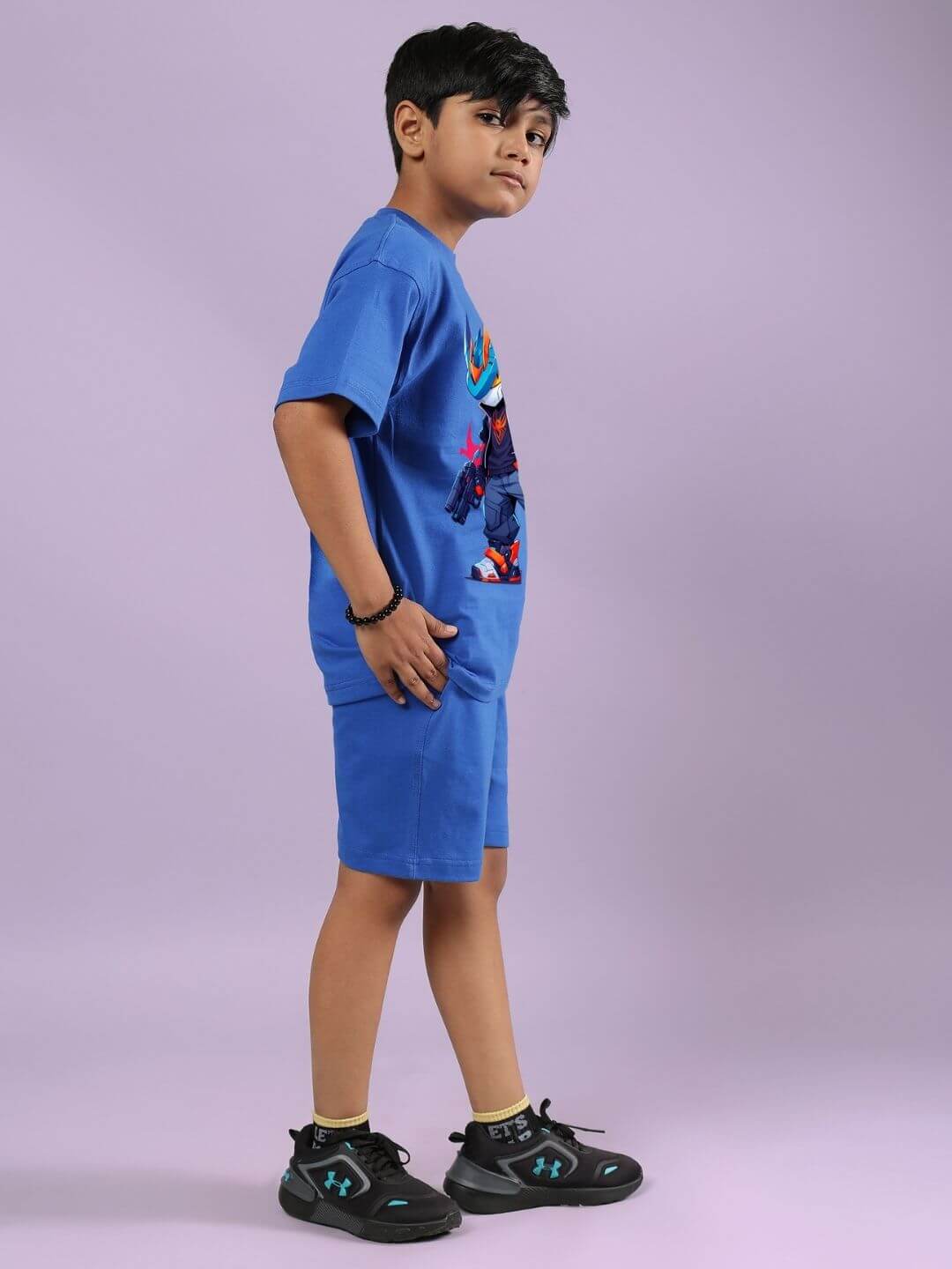 Child wearing blue Robo Super Co-ord Set with graphic T-shirt and shorts, side profile, purple background, kids fashion outfit.
