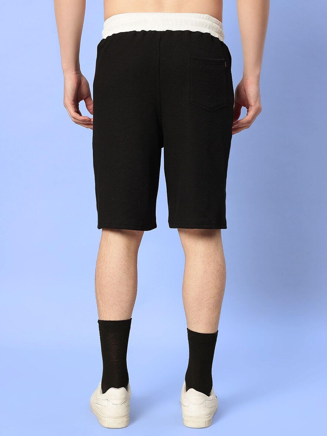 Back view of the ROBSON CO-ORD SET in black, featuring waffle fabric shorts. 100% cotton, showcasing relaxed fit. Model is 6 feet tall.