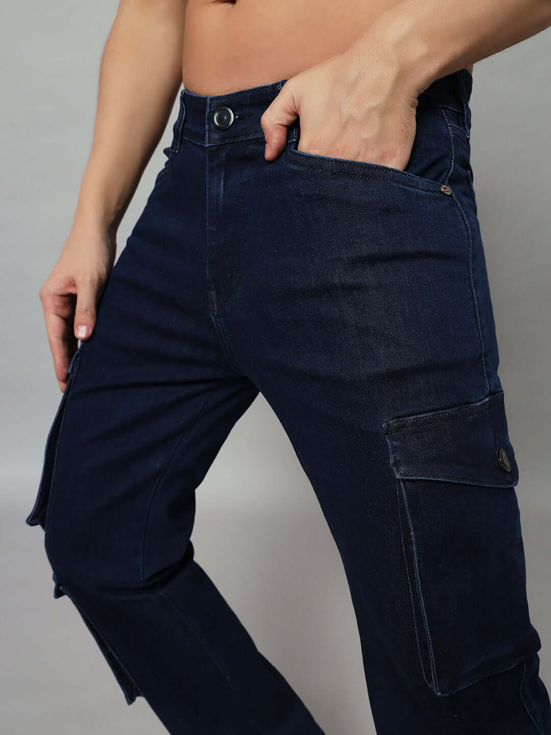 Model wearing navy robust relaxed denim cargo jeans, featuring functional pockets and custom fit options by DUDS.