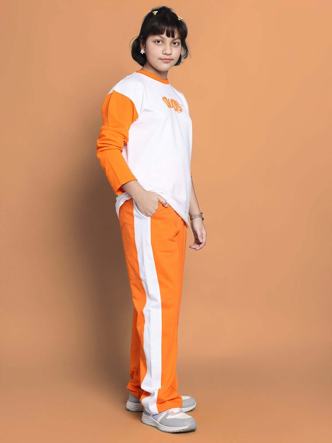 Child wearing Rock & Roll oversized white and orange co-ord set with elasticated waistband and contrast panel joggers.