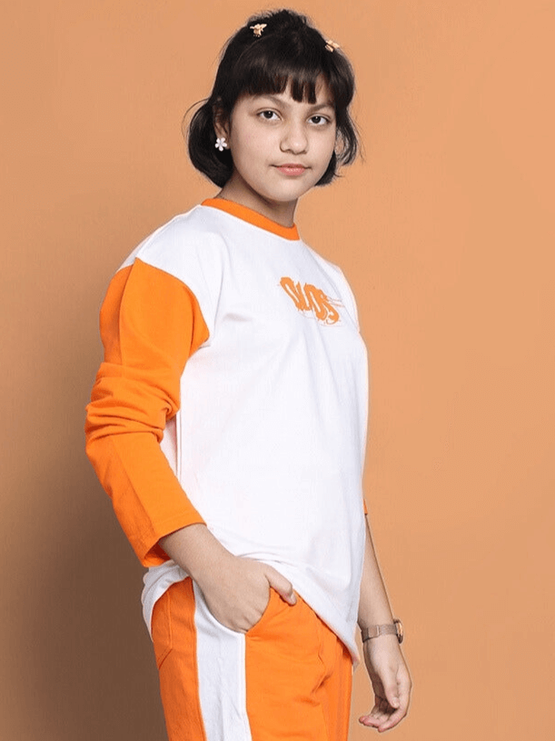 Boy wearing a white and orange oversized rock & roll sweatshirt made from 100% cotton, standing against an orange backdrop.