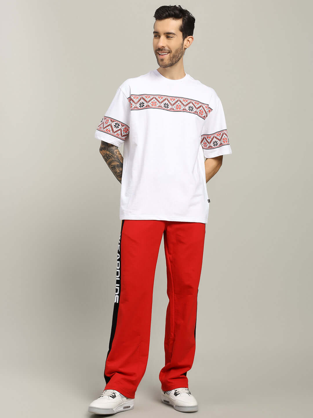 Man wearing ROGER RELAXED-FIT JOGGERS RED MEN with white print t-shirt and sneakers