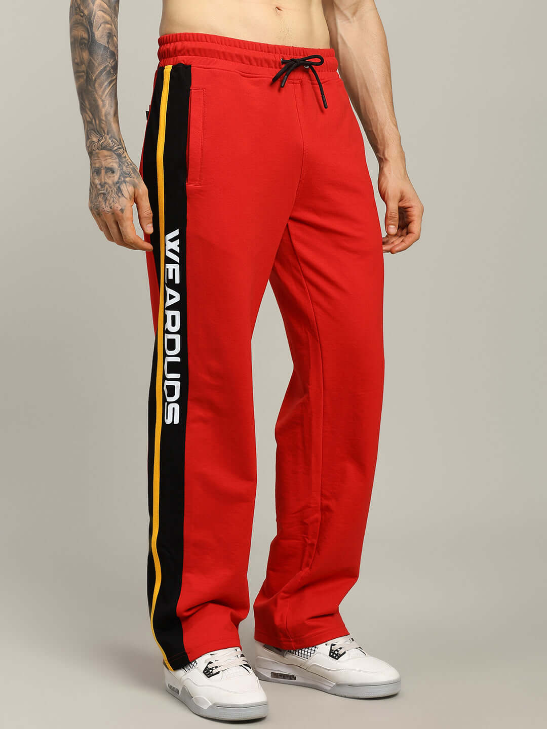 Model wearing ROGER RELAXED-FIT JOGGERS RED MEN with side stripe detail.