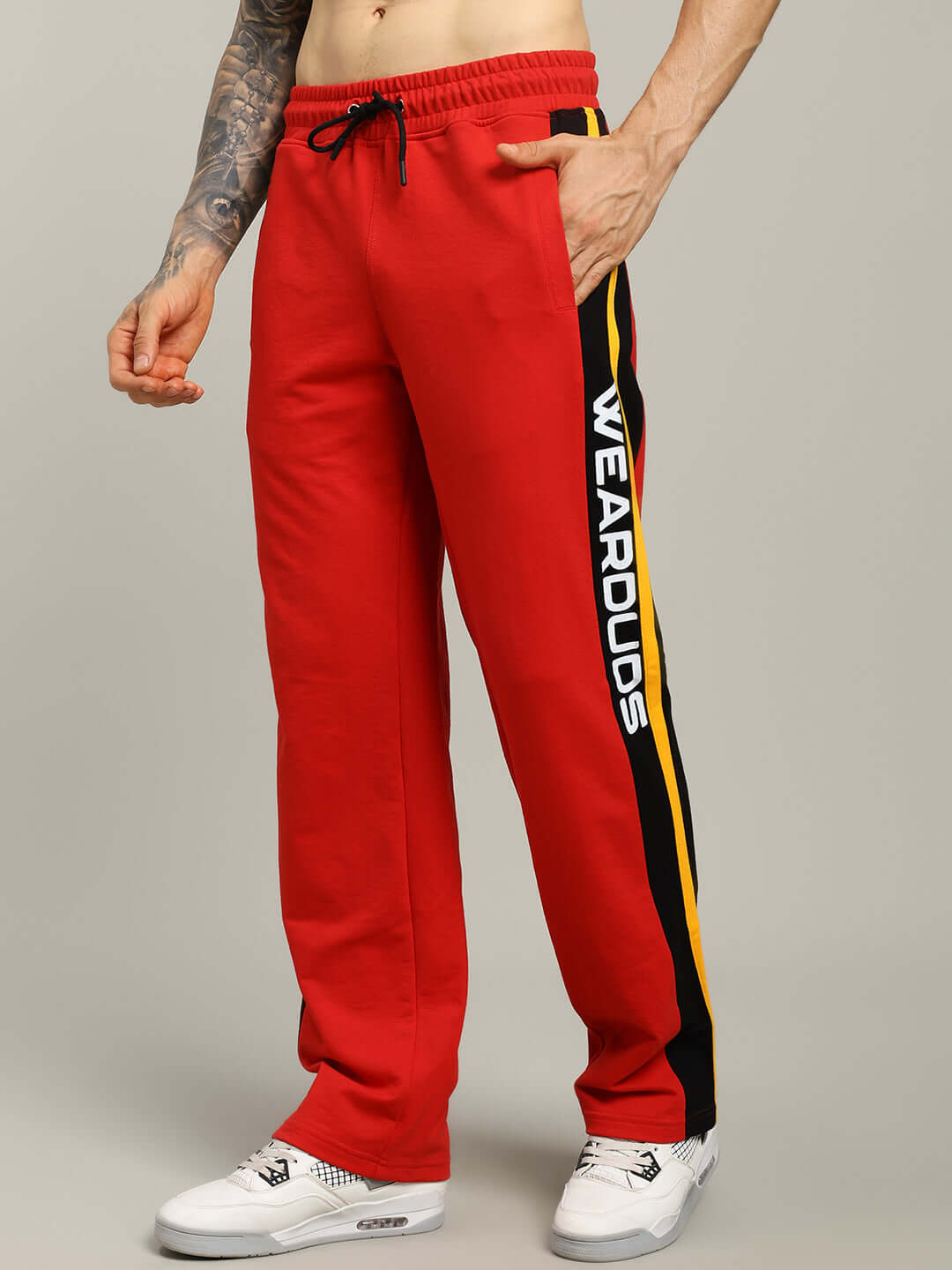 Male model wearing ROGER RELAXED-FIT JOGGERS RED MEN with side stripe detailing.