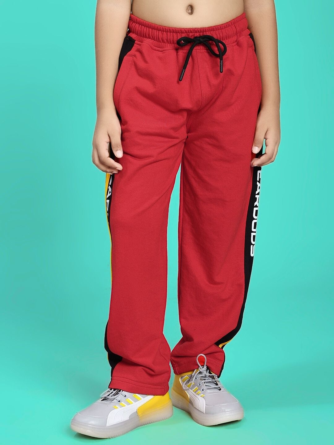 Child wearing ROGER RELAXED-FIT JOGGER FOR BOYS AND GIRLS RED BLACK with sneakers.