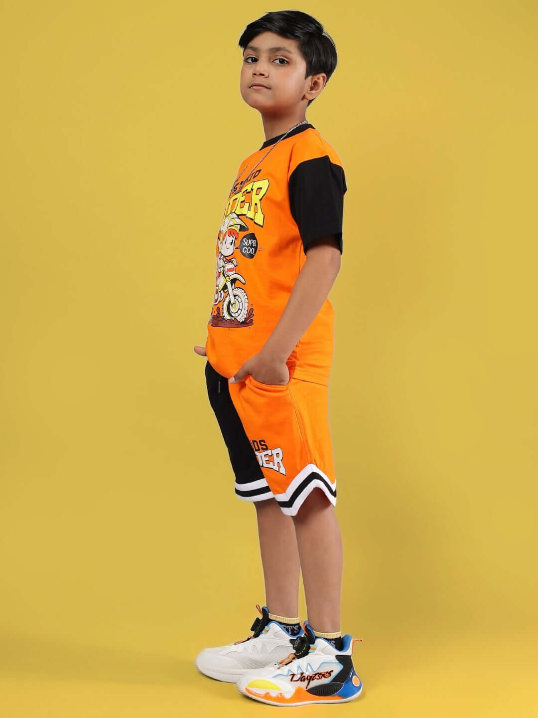 Child wearing ROGUE RIDER CO-ORD FOR BOYS & GIRLS ORANGE BLACK, featuring an orange and black outfit with graphics.