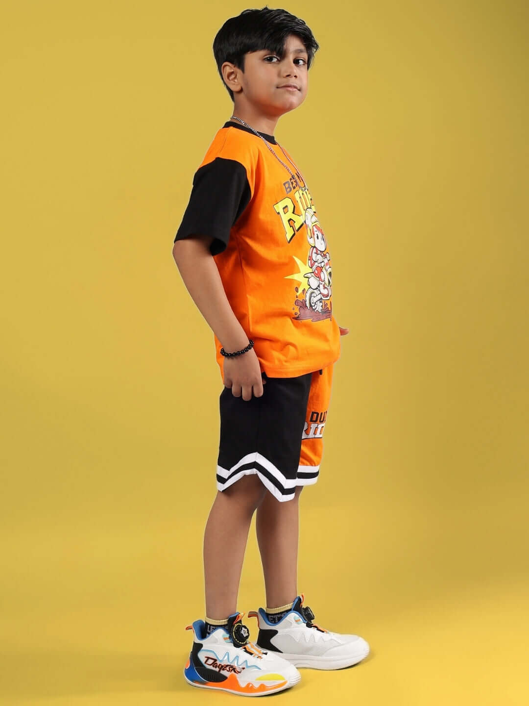 Child wearing ROGUE RIDER CO-ORD FOR BOYS & GIRLS ORANGE BLACK in vibrant setting