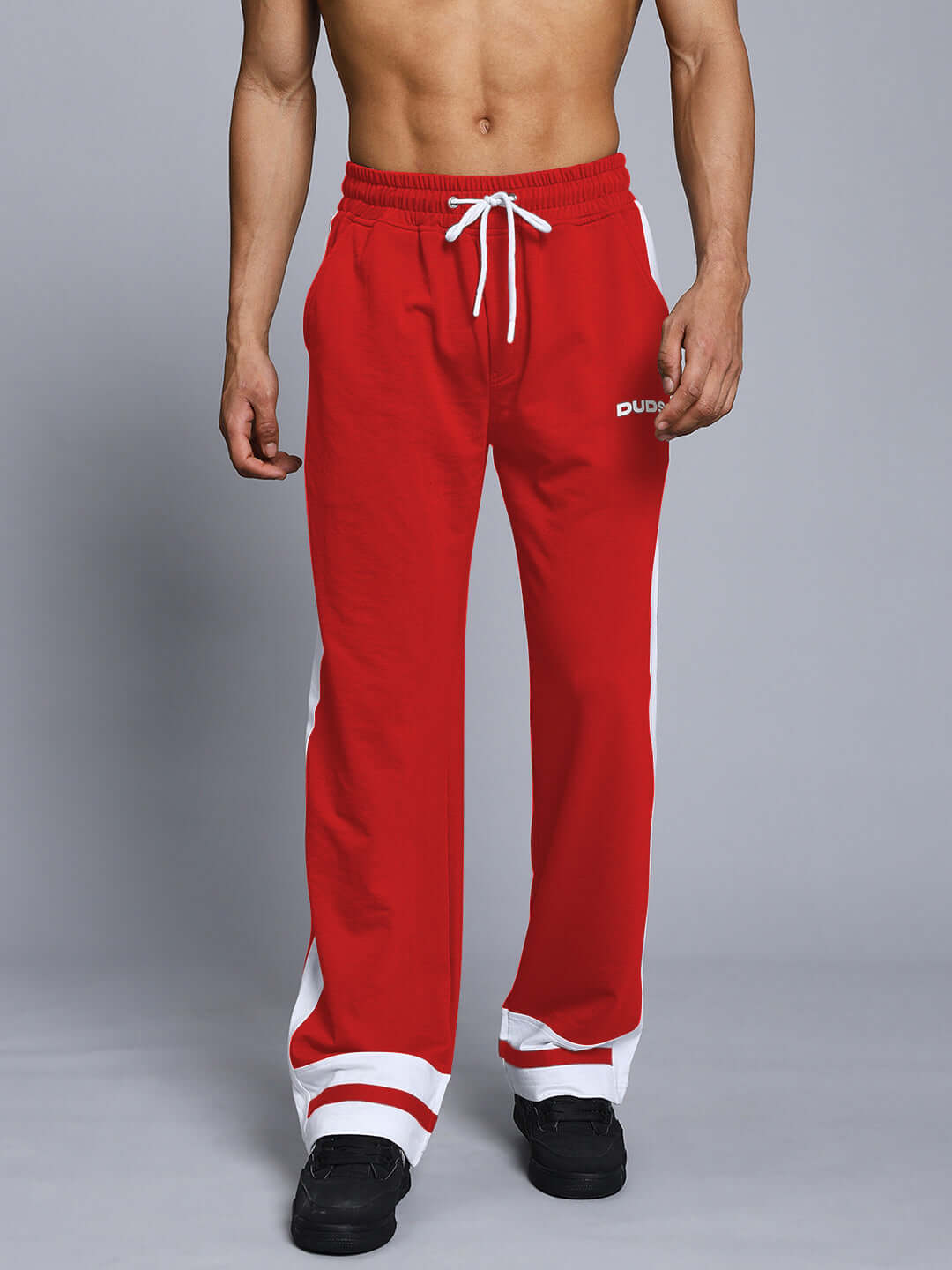 Red and white jogger pants with side stripes worn by a male model, showcasing the RONNY SIDE STRIPE design by DUDS.