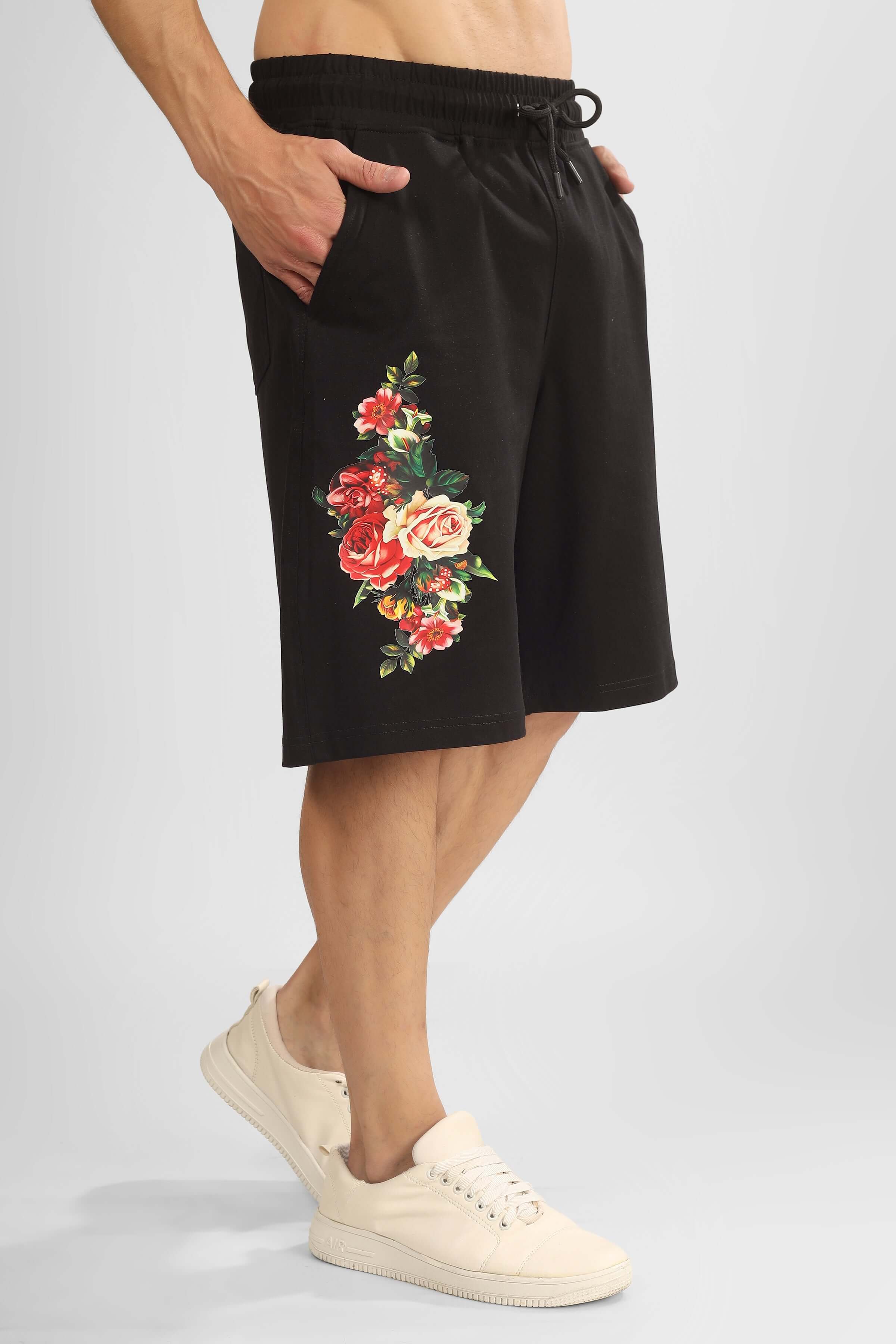 Black regular fit shorts with floral embroidery design on the side, worn by a model with sneakers, customizable for perfect fit.