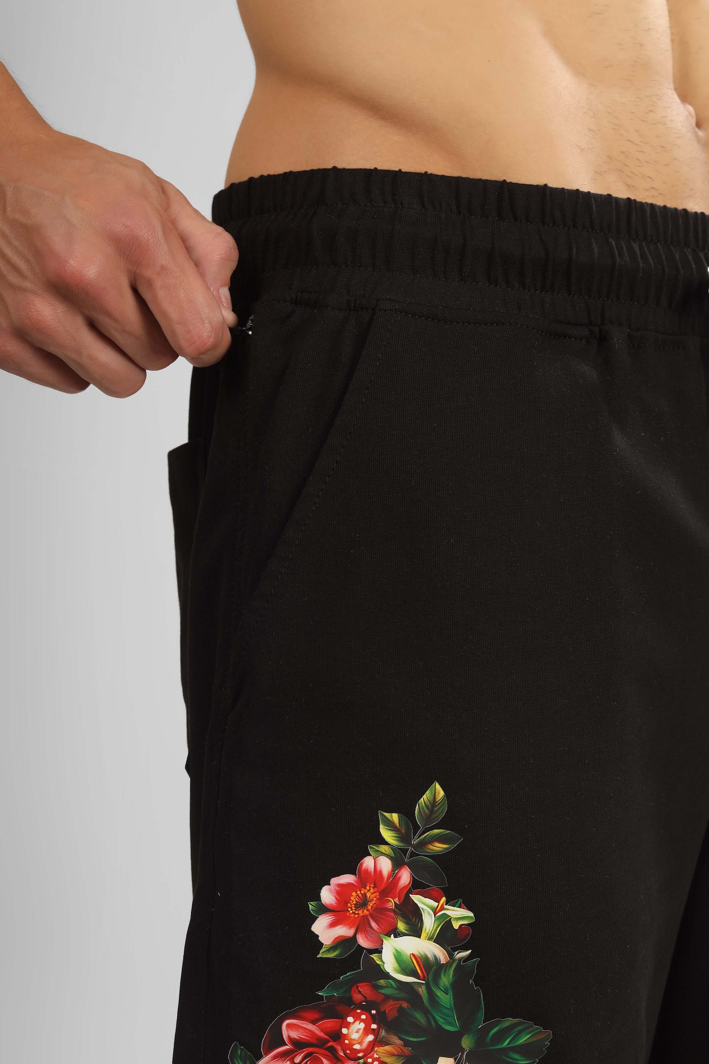 Black shorts with rose design, showcasing elastic waistband and floral detail, customizable to fit your preference for a perfect look.
