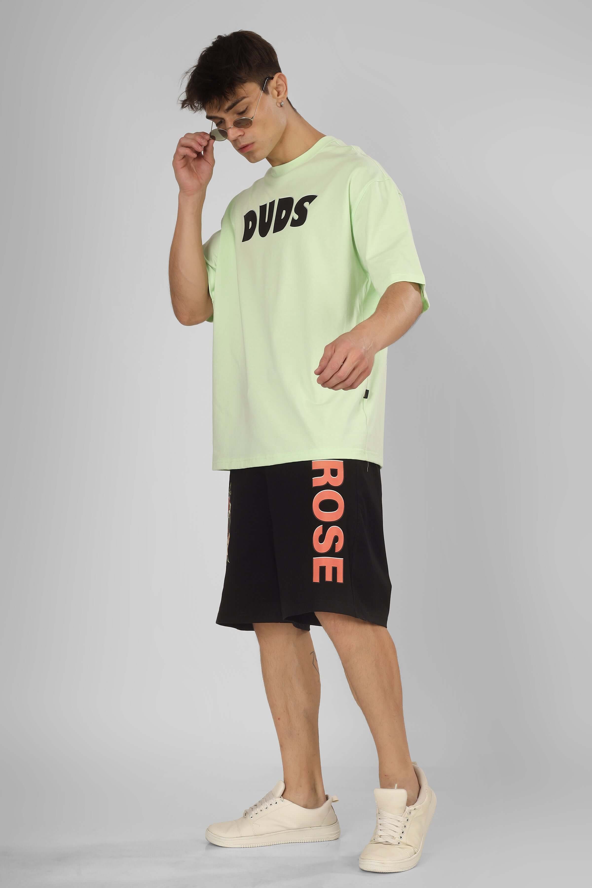 Fashion model wearing ROSE regular fit black shorts by DUDS, paired with a mint-green shirt, showcasing a casual look.