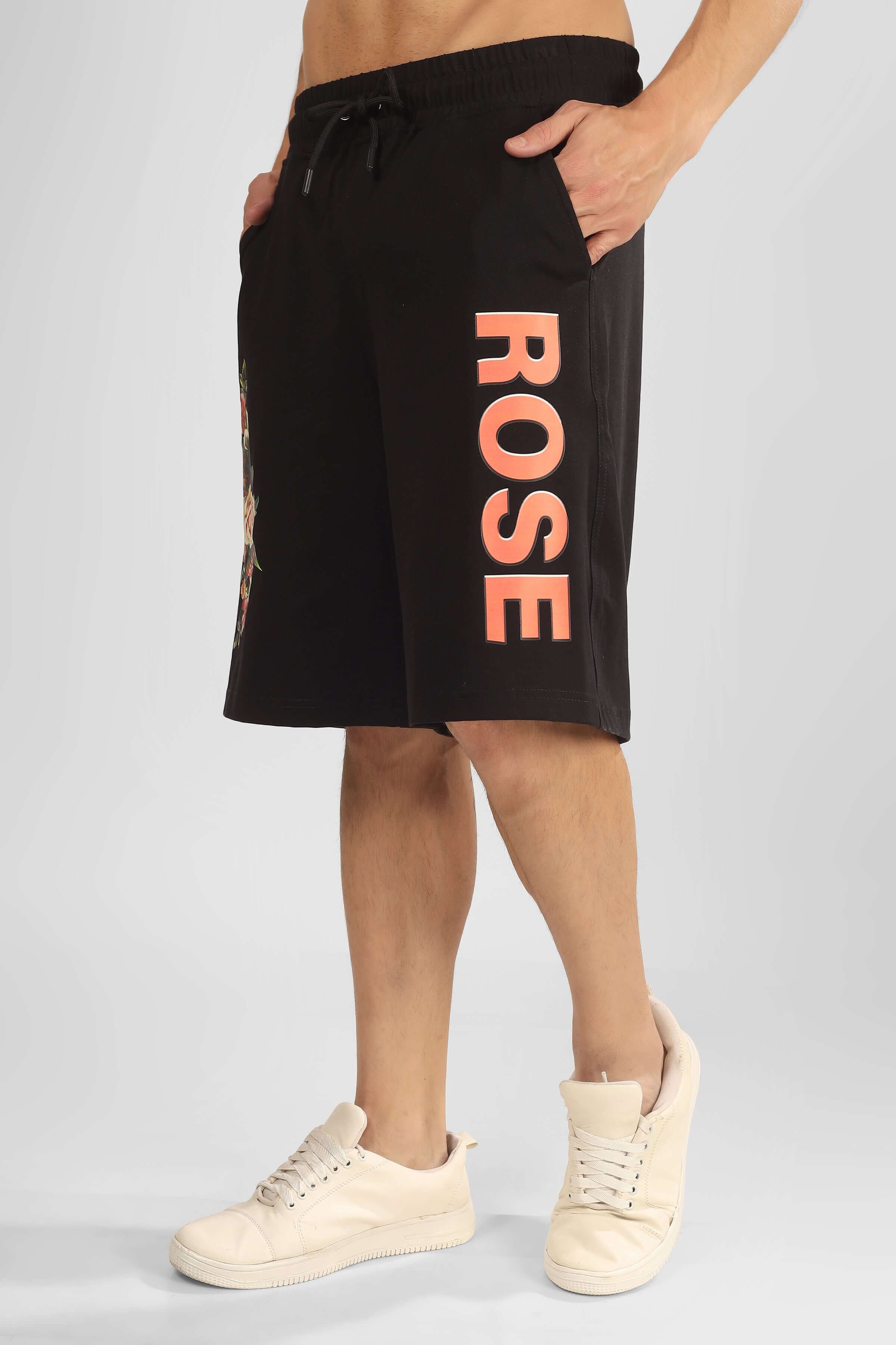 Model wearing ROSE regular fit black shorts, side view showcasing design and length, paired with white sneakers, customizable size options available.