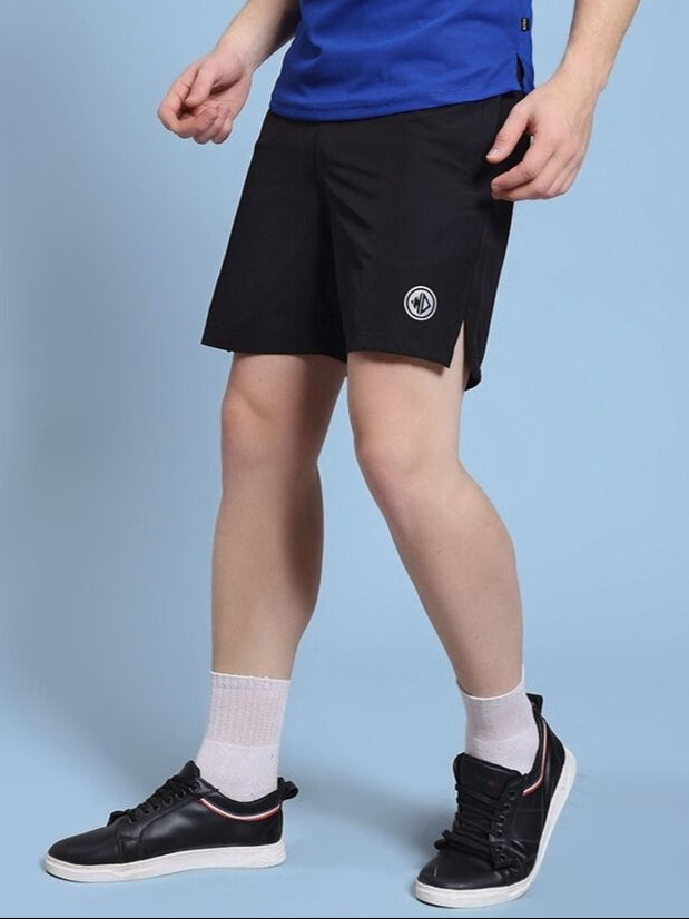 Person wearing ROSEWOOD RELAXED FIT SHORTS BLACK with sneakers and blue top, showcasing casual streetwear style.