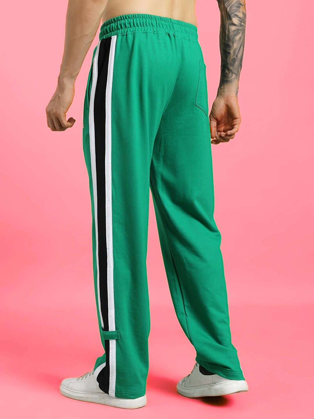 Model wearing ROSSTON FLAT-OUT RELAXED FIT JOGGERS GREEN with stripe design, showcasing streetwear style and comfort.