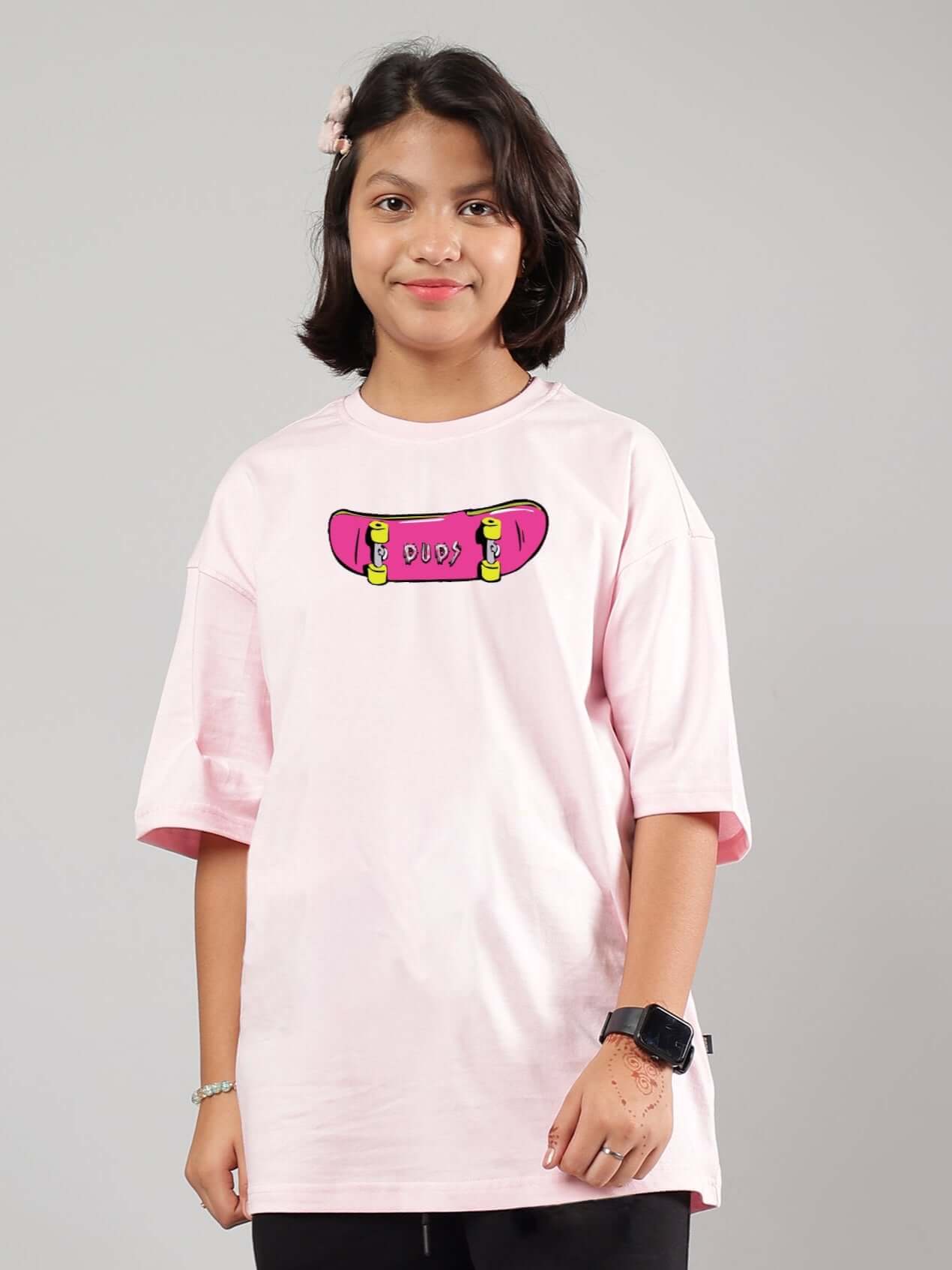 Young person wearing ROWDY APE oversized pink t-shirt for boys & girls, featuring a skateboard design, available in custom fit by DUDS.