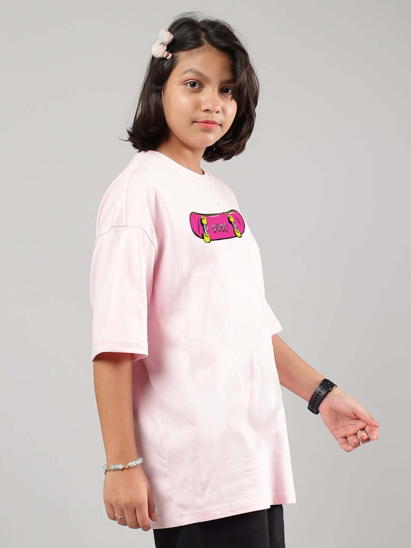 A young person wearing a pink oversized t-shirt with a colorful graphic, showcasing the "ROWDY APE" design, perfect for boys and girls.