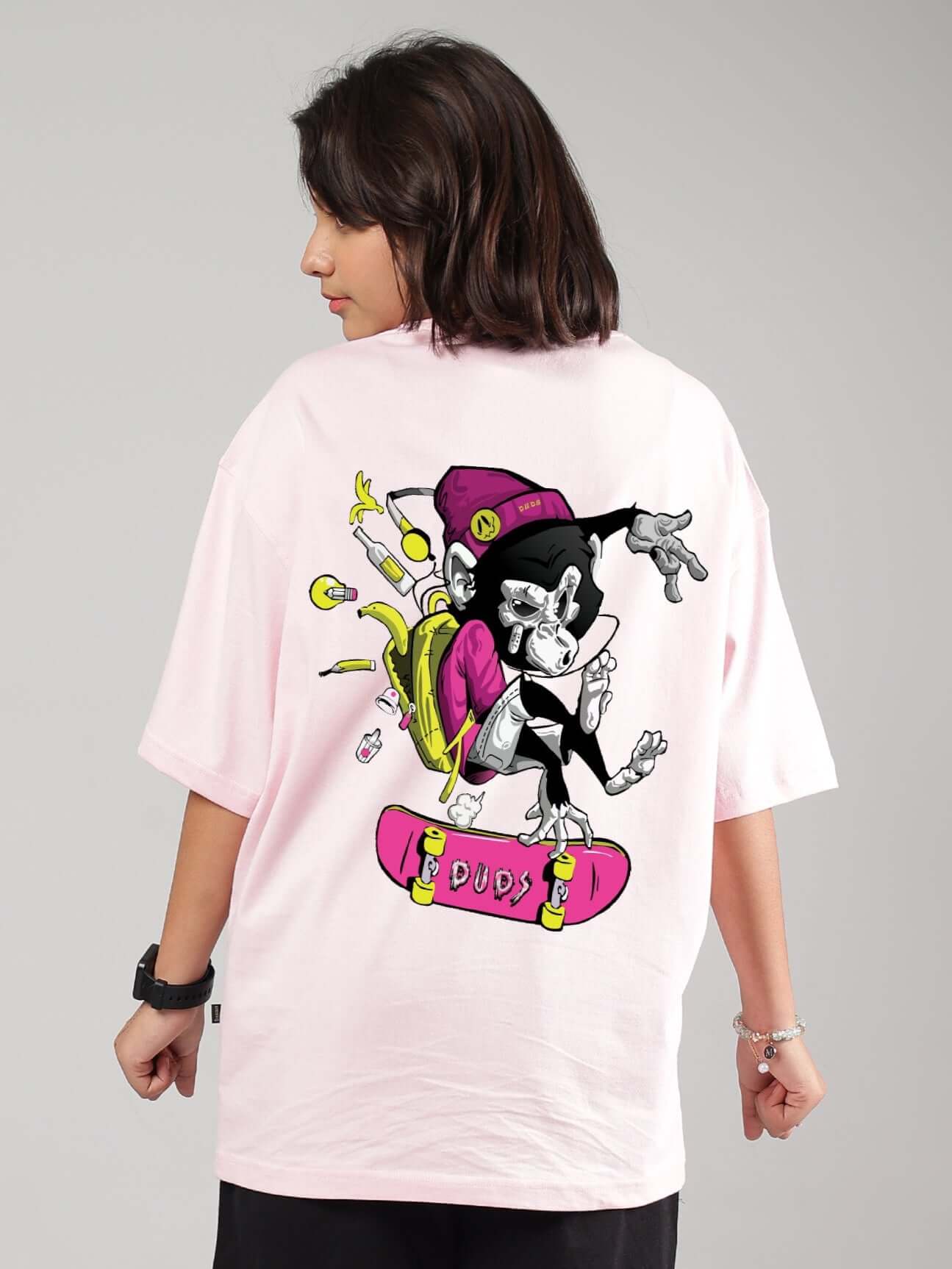 Model wearing a pink oversized ROWDY APE T-shirt for boys & girls by DUDS with vibrant ape graphic on back.