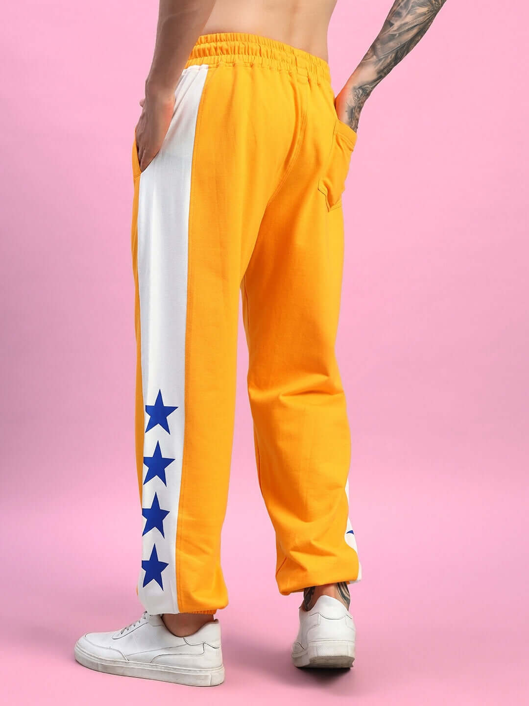 ROX Primer relaxed fit joggers in orange-white with blue star detailing, showcased on male model, emphasizing comfort and style.