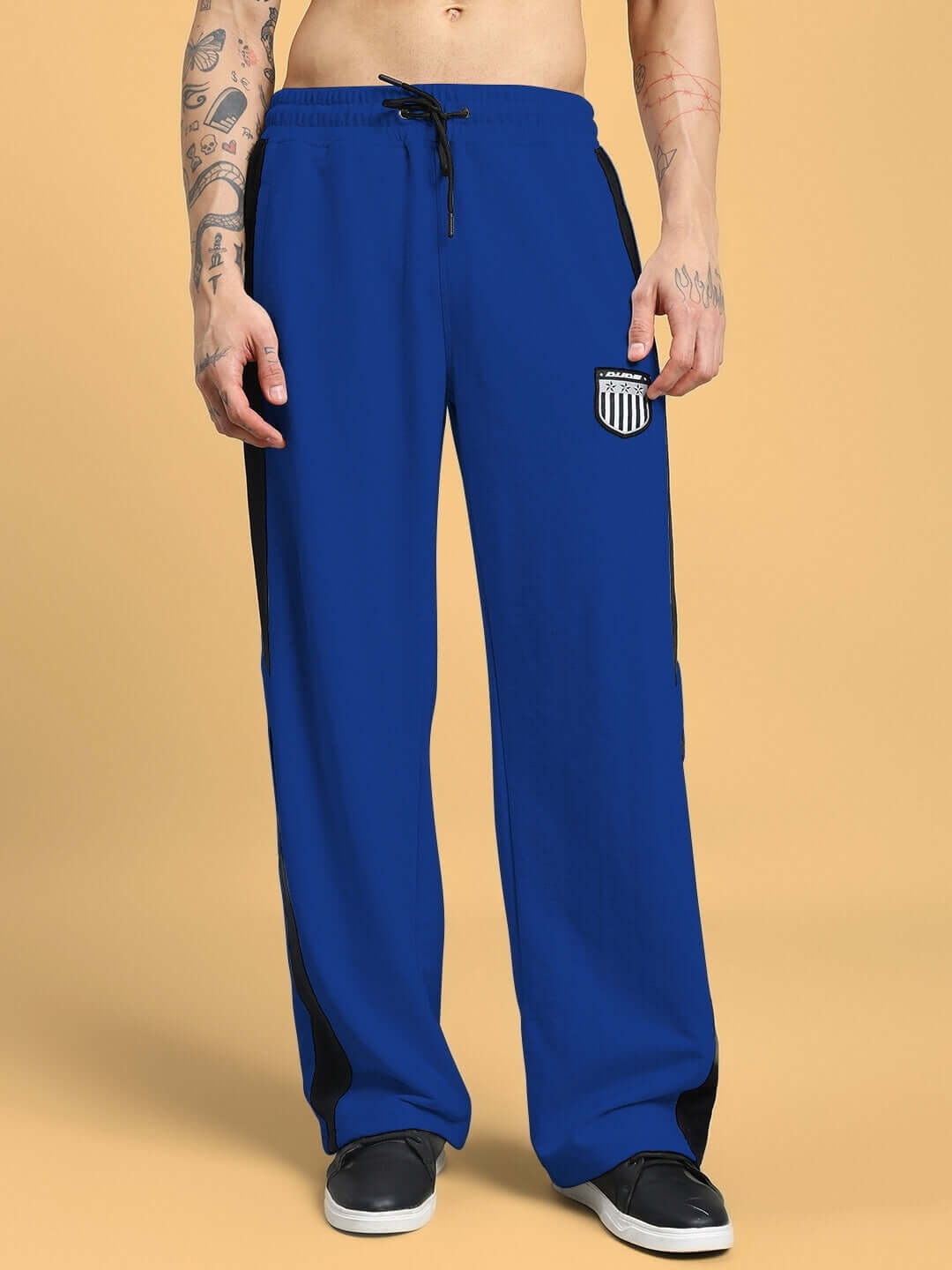 Man wearing royal blue ROYALSON joggers from DUDS, showcasing comfortable fit and drawstring waist, customizable size option available.