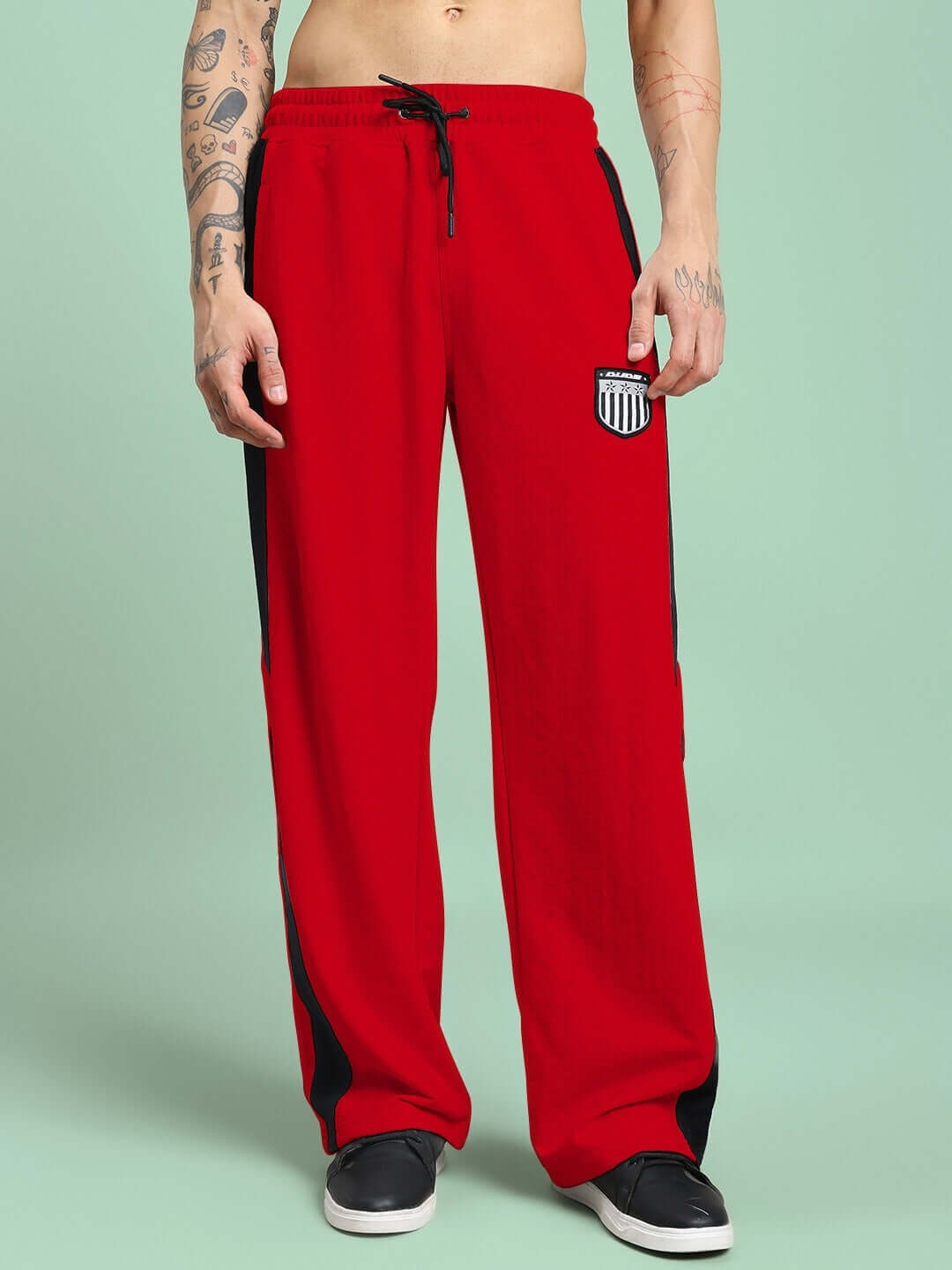 Model wearing ROYALSON red joggers with black stripes, available in custom fit; tailored by DUDS. Shipping in 7-10 days as made-to-order.