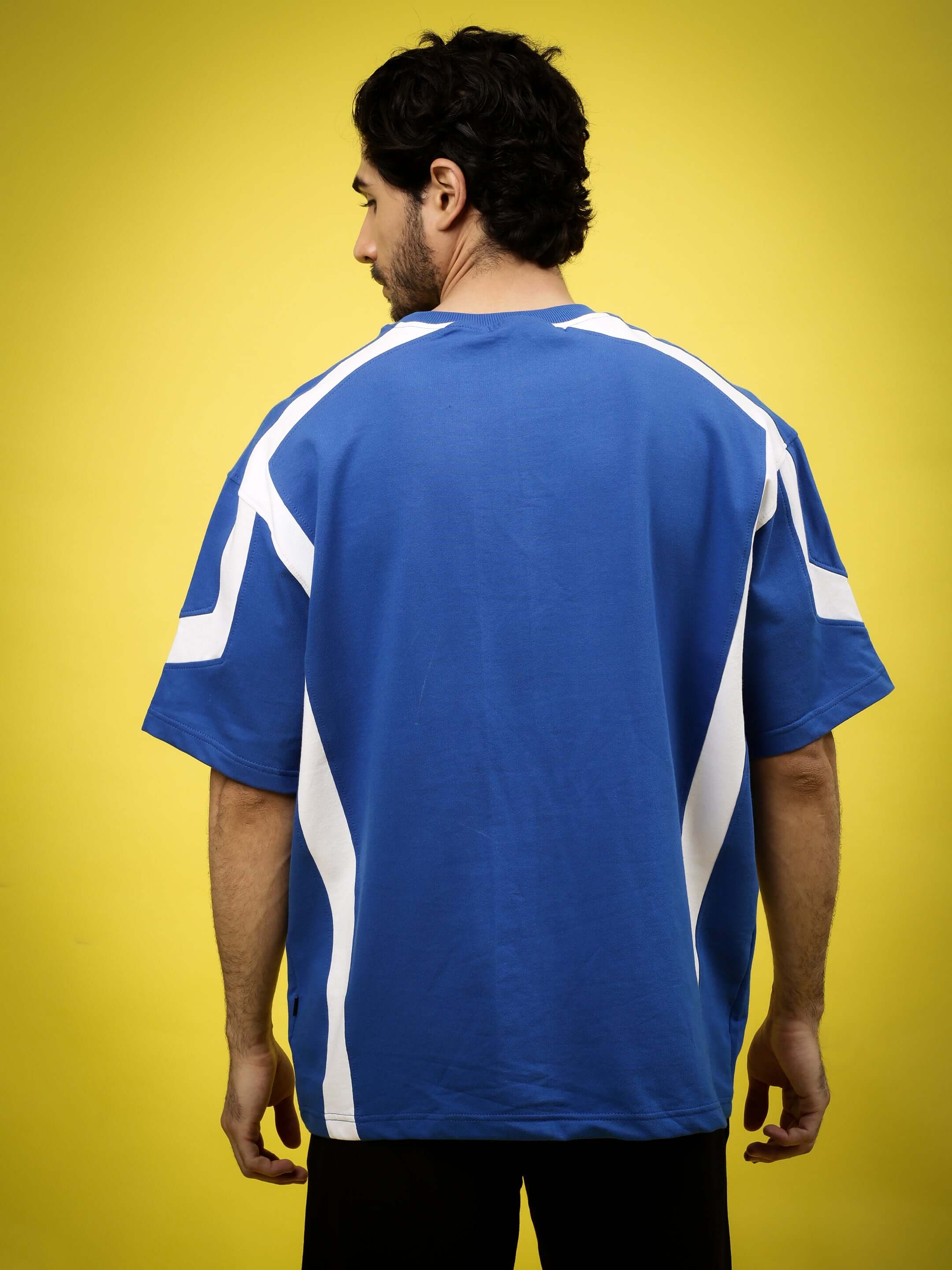 Man wearing a royal blue and white rugby oversized t-shirt made from premium cotton.