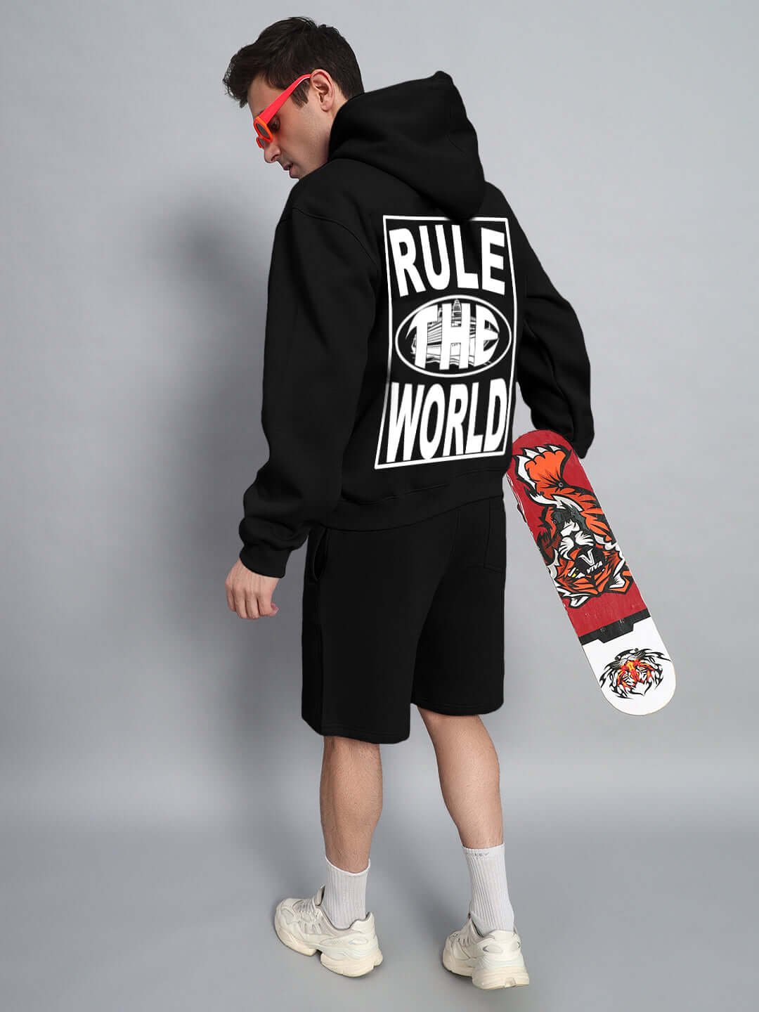Person wearing RULE THE WORLD FLEECE CO-ORD - BLACK with skateboard, showcasing casual street style and comfort.
