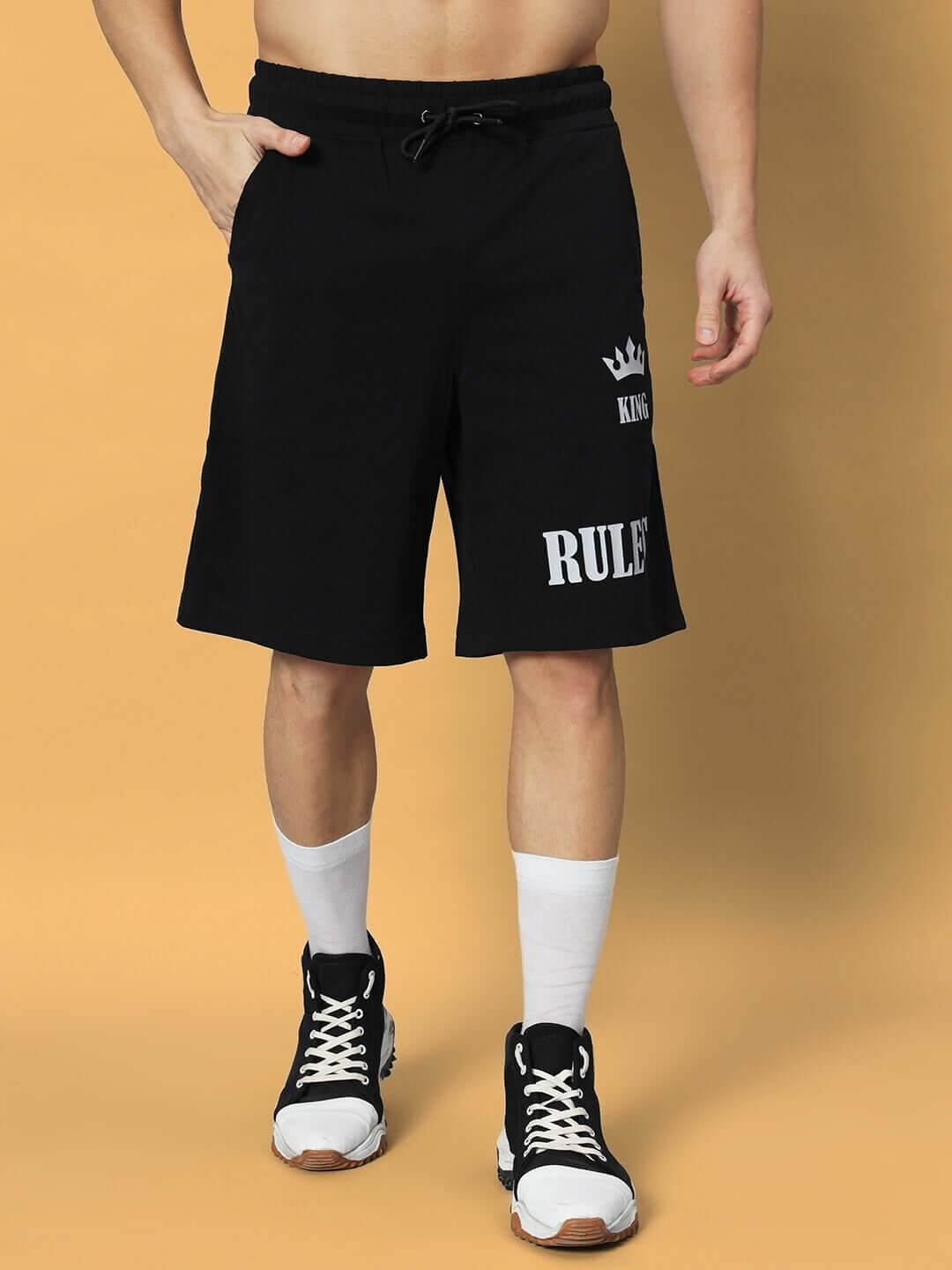 Model wearing black RULES KING shorts, showcasing athletic fit and style, paired with sneakers, highlighting design and comfort.