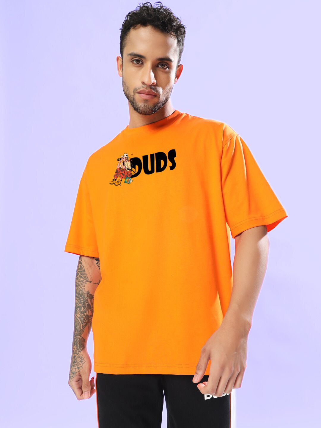 SAFARI PRINTED OVERSIZED T-SHIRT ORANGE worn by person, showcasing comfortable and stylish design on lavender background.